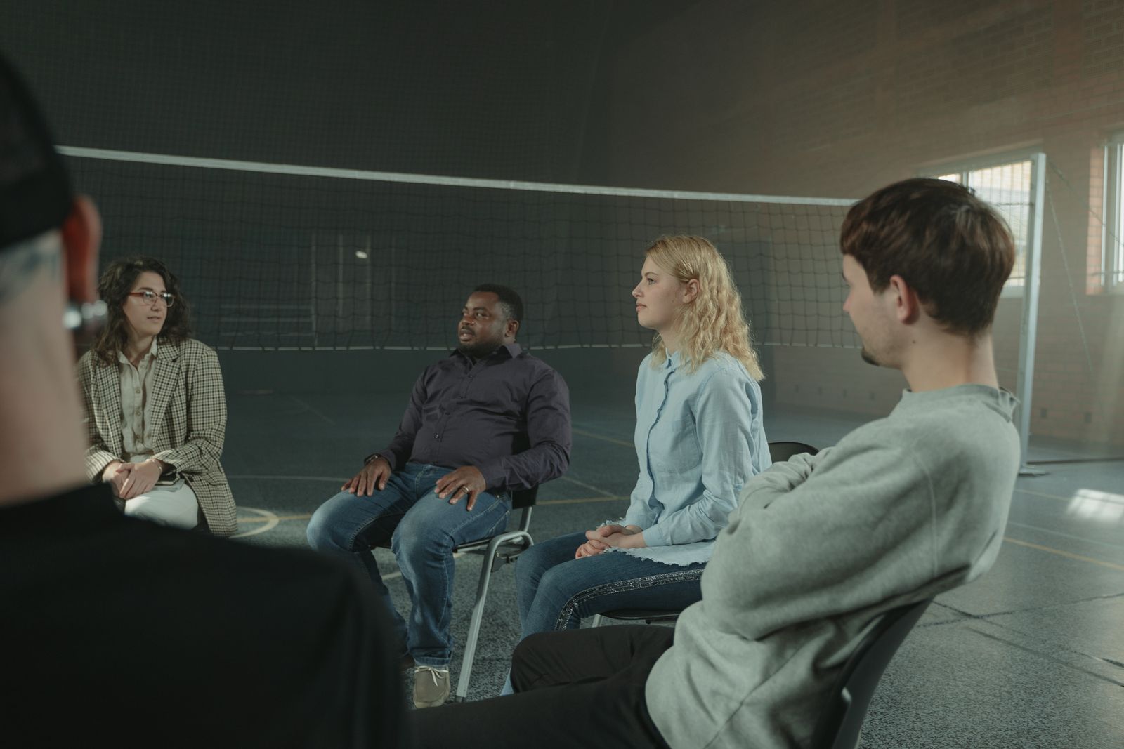 A small group of adults in conversation together in a bright room
