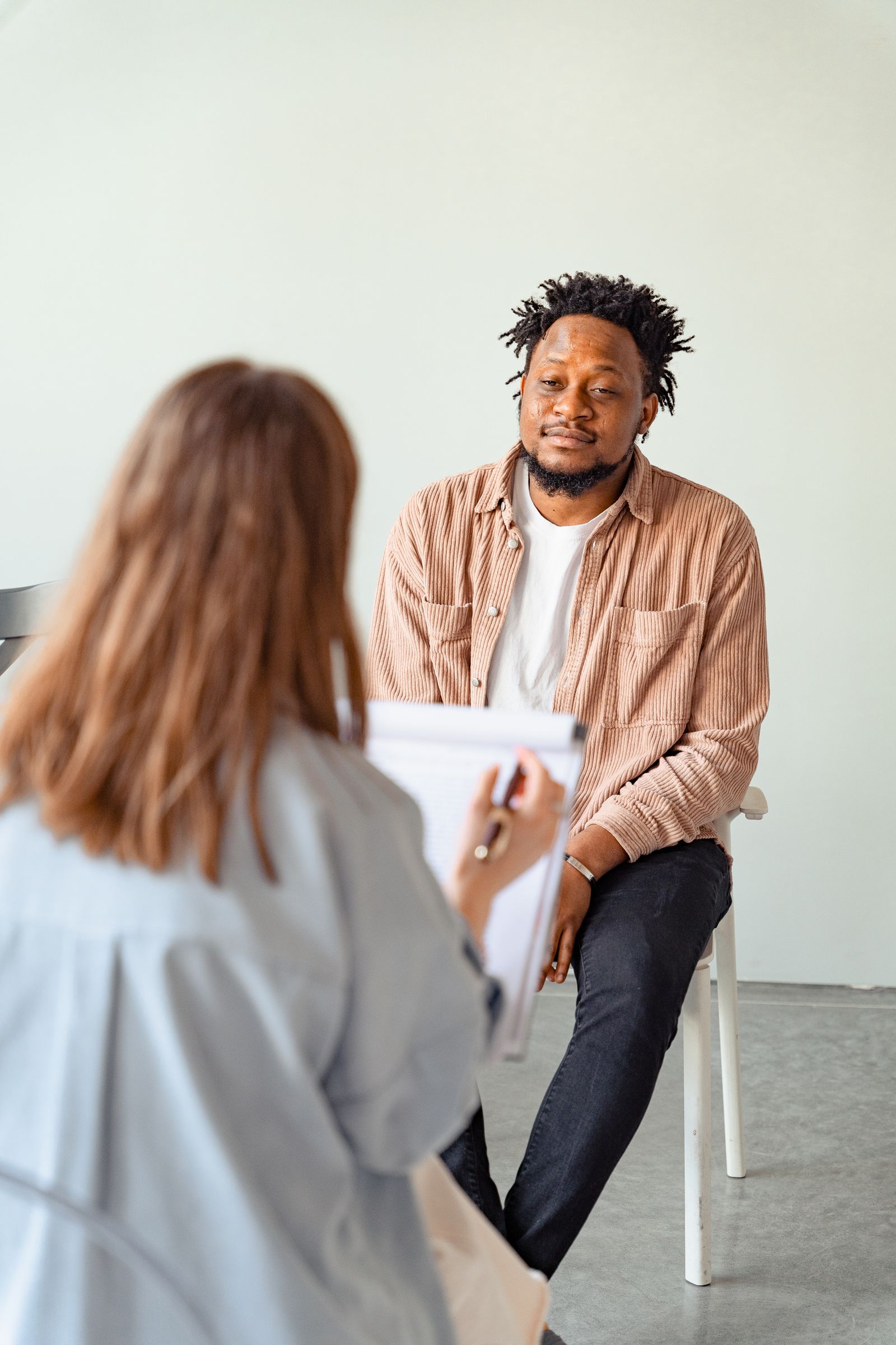 An adult in a calm one-on-one session with a clinician in a warm room