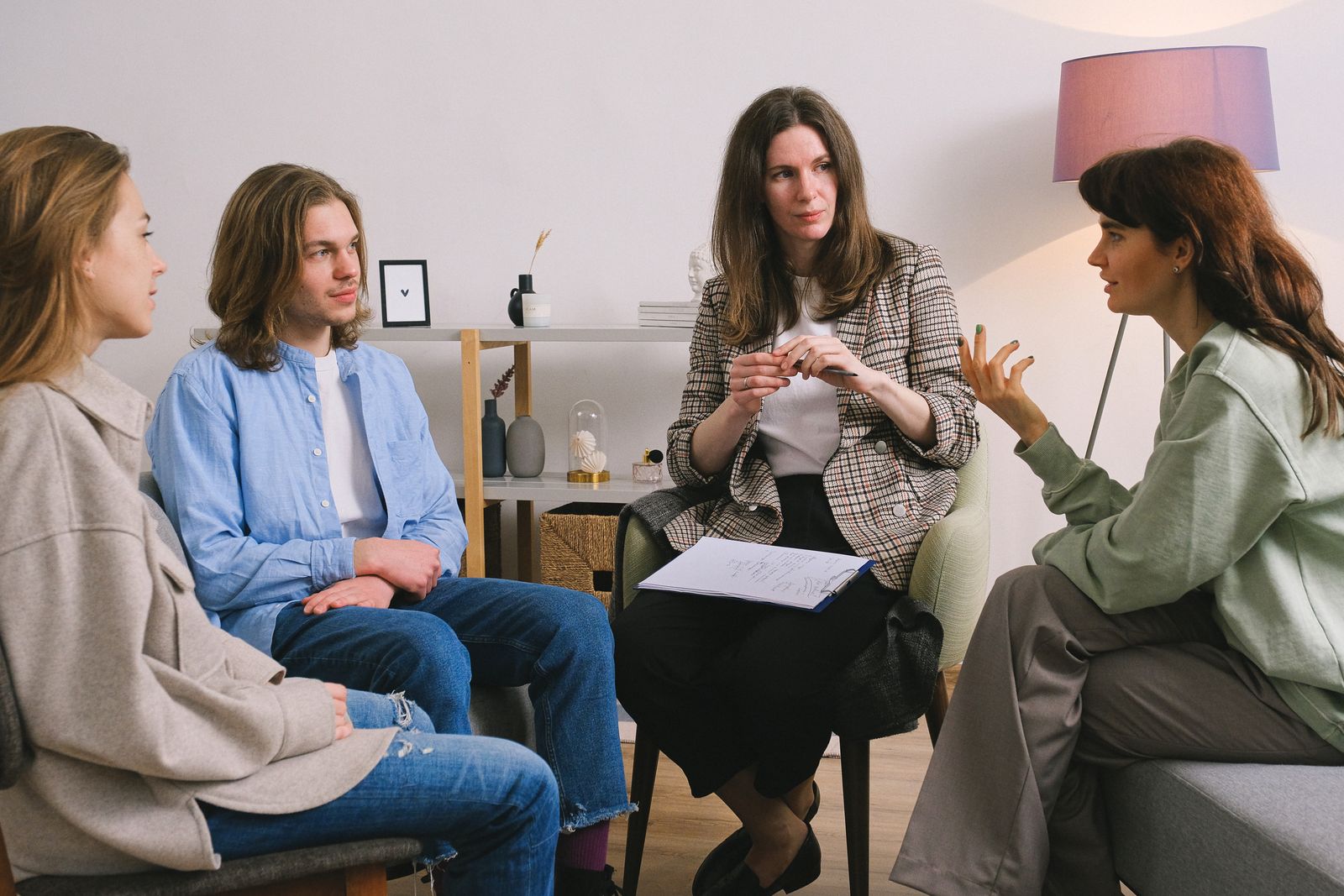A small circle of adults talking together in a bright room
