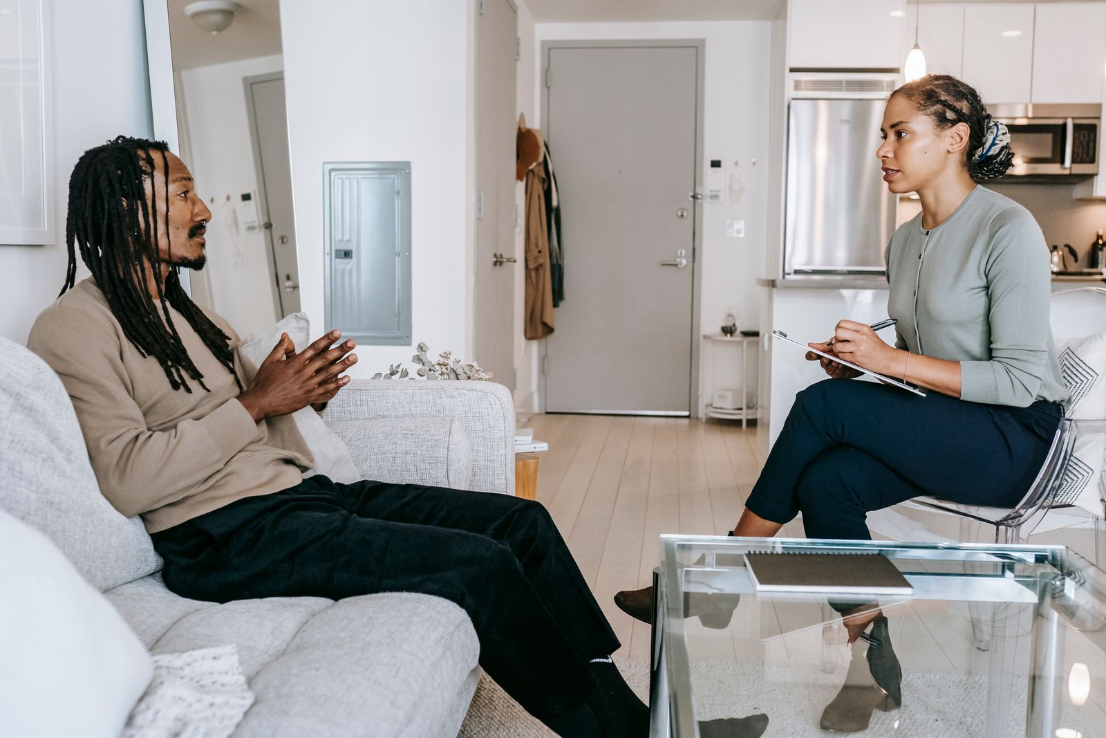Two adults in a calm one-on-one conversation in a warm, private room