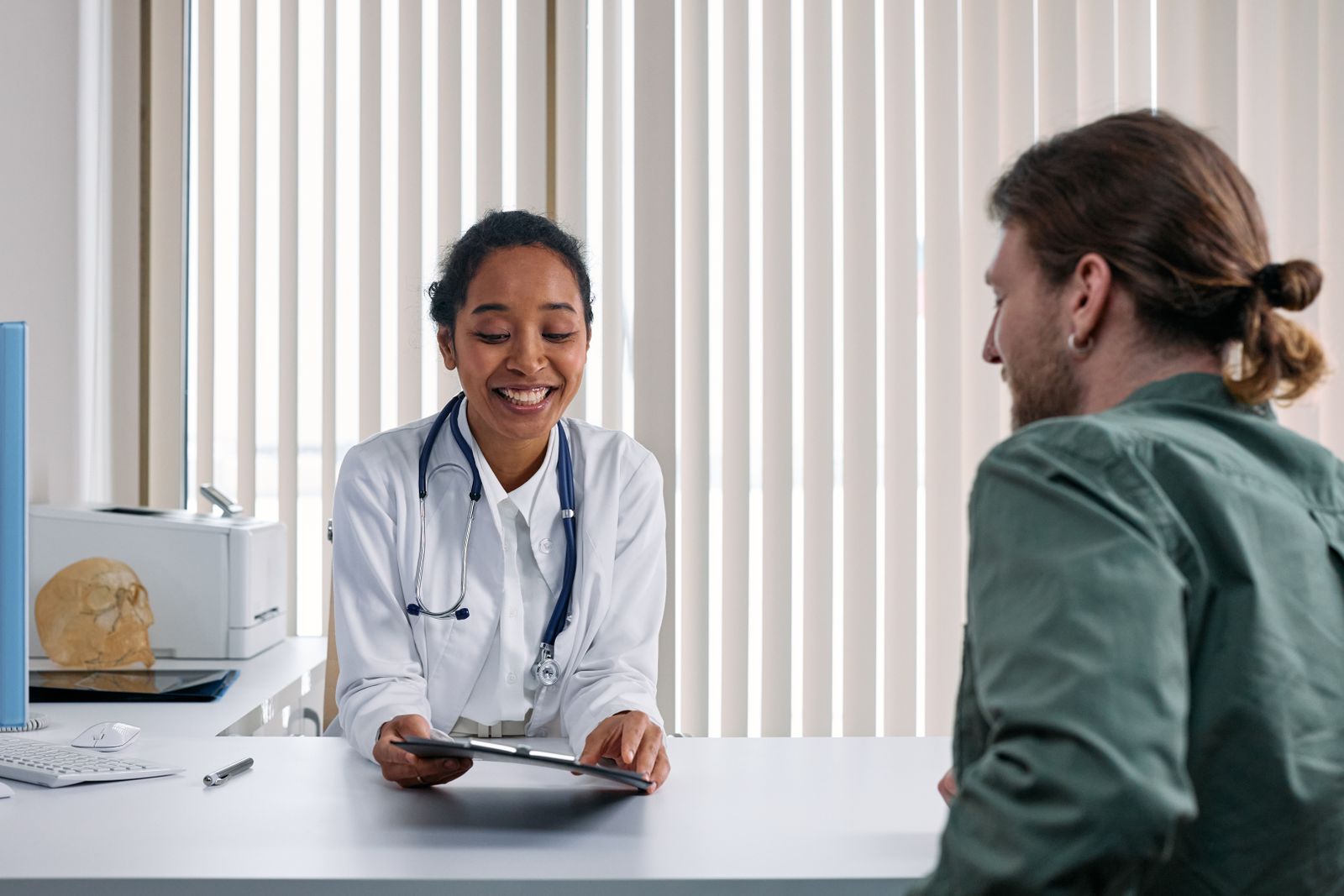 A clinician talking with an adult patient in a calm consultation