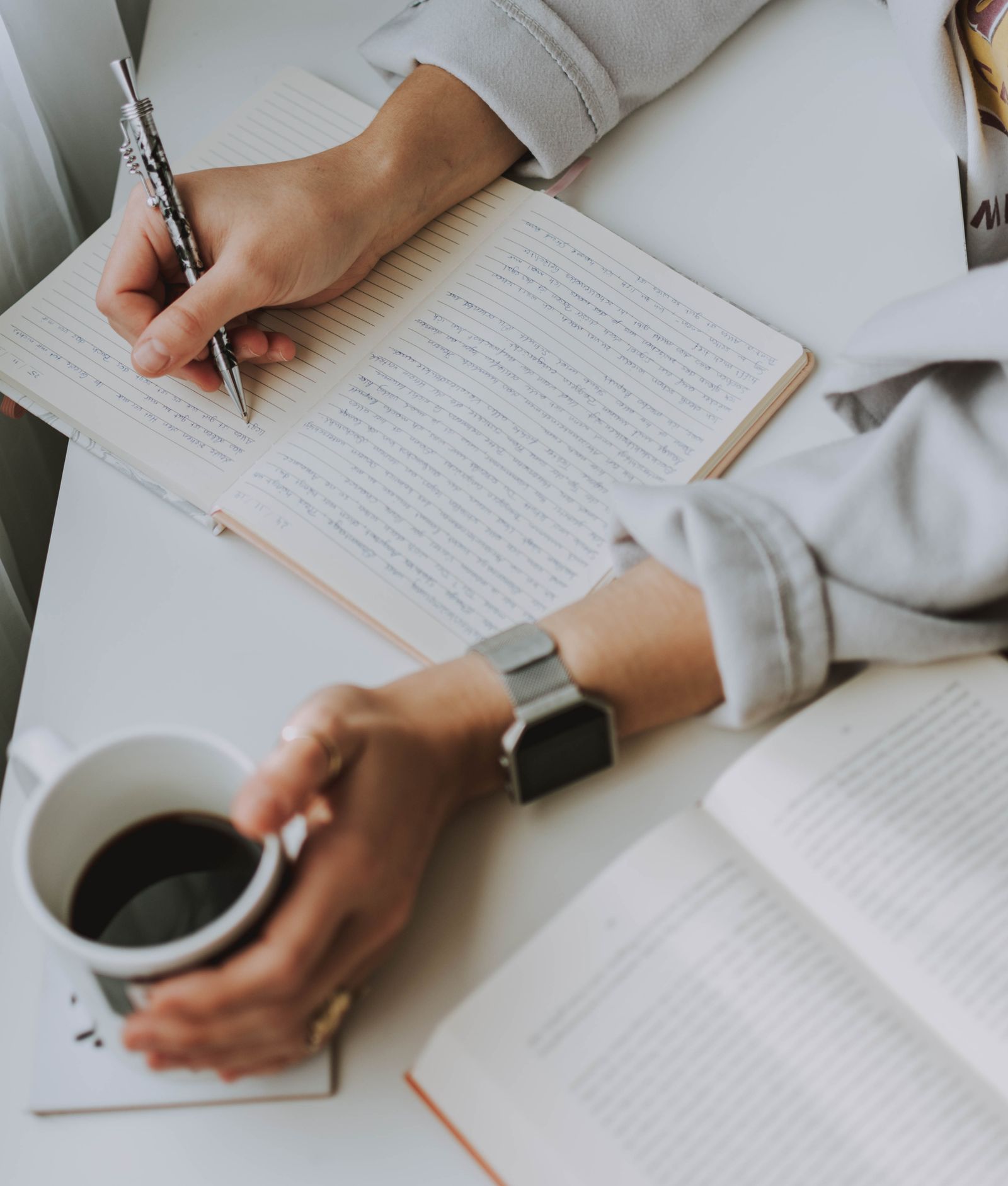An adult journaling at a table in calm morning light